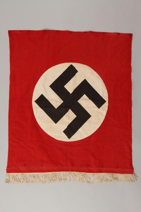 Estandarte rojo con una esvástica negra dentro de un círculo blanco.